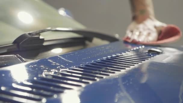 Close up van de master polijsten diep blauwe auto in de werkplaats, slow-motion — Stockvideo