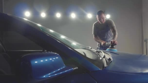 Master polishes the deep blue sport car via polish mashine in a car workshop — Stock Video