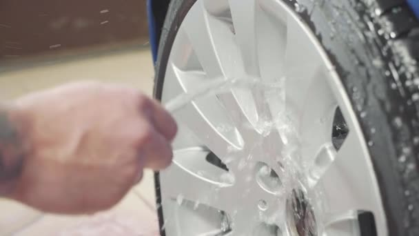 Hombre usando química para limpiar rueda de coche deportivo, cámara lenta — Vídeo de stock