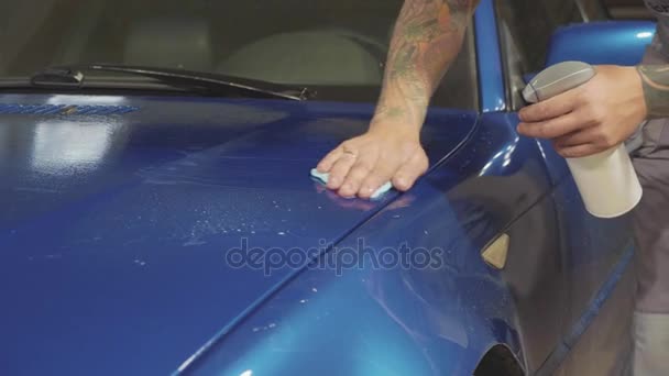 Zbliżenie na master polerowania głęboko niebieski samochód w warsztacie, w zwolnionym tempie — Wideo stockowe