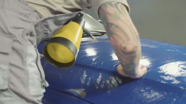 Close up of master polishing deep blue car in workshop, slow motion — Stock Video