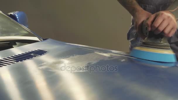 マスターが車のワーク ショップでポーランド機を介して深い青色のスポーツ車を磨く — ストック動画