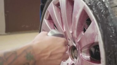 Spor araba tekerleği, ağır çekim temizlik için kimya kullanan adam