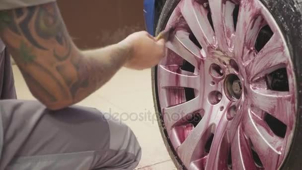 Hombre usando química para limpiar rueda de coche deportivo, cámara lenta — Vídeos de Stock