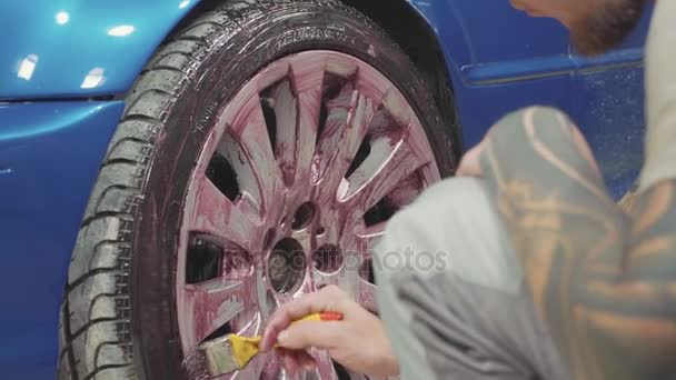 Homme utilisant la chimie pour nettoyer la roue de voiture de sport, au ralenti — Video