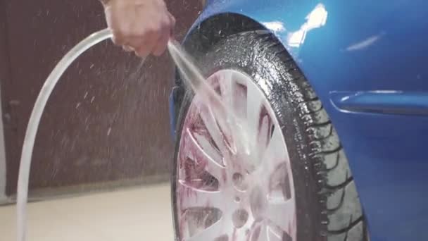 男子使用化学清洁运动车车轮, 慢动作 — 图库视频影像