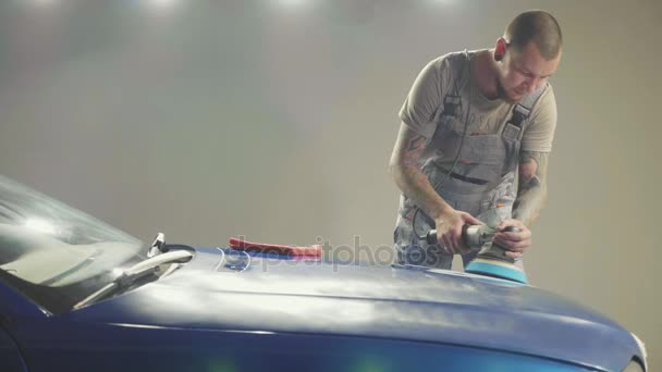 Master polerar den djupblå sportbil via polska maskin i en bilverkstad — Stockvideo