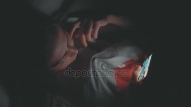 Genç kadın geceleri yatağa cep telefonu kullanarak