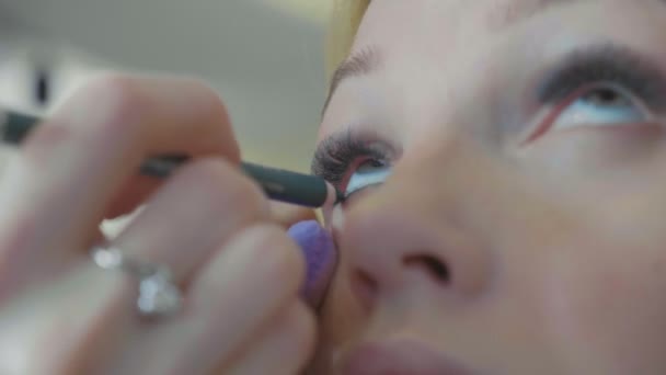 Joven artista de maquillaje aplicando cosméticos en los ojos modelos . — Vídeos de Stock