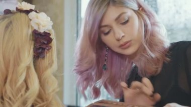 Kozmetik modelleri gözünü uygulayarak genç makyaj sanatçısı.