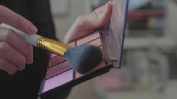 Une palette avec des ombres à paupières et un pinceau de maquillage : cosmétiques pour femmes . — Video