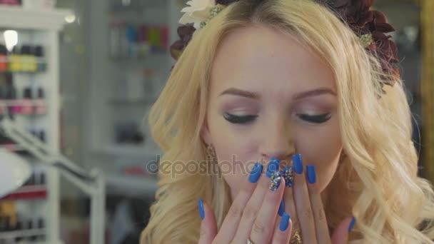 Mooie blonde vrouw met lang krullend haar en stijl make-up poseren op camera — Stockvideo