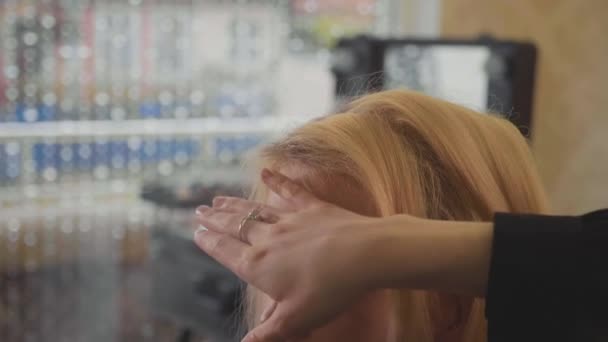Estilista profesional haciendo peinado para mujer joven y usando spray para el cabello — Vídeos de Stock