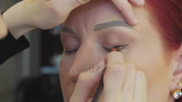 Maquillaje artista aplicación de maquillaje a los modelos de ojo. Vista de cerca . — Vídeos de Stock