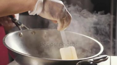 Şef çelik wok, yakın çekim ağır çekim bir omlet pişirme.