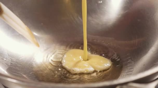 Ovos batidos derramando em óleo fervido em wok. Processo de cozimento omelete close-up — Vídeo de Stock
