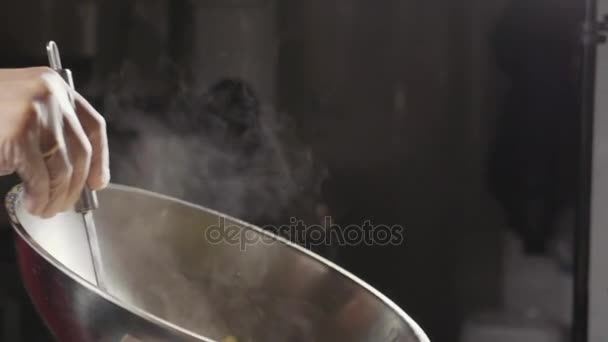 Chef-kok koken een omelet in stalen wok, close-up Slowmotion. — Stockvideo