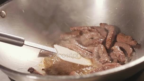 Nahaufnahme vom Koch, der Fleisch in der Wok-Pfanne kocht. Fleisch in kochender Butter gebraten, Zeitlupe — Stockvideo