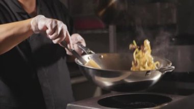 Şef bir noodle ile et ve sebze wok tavada pişirme Close-Up