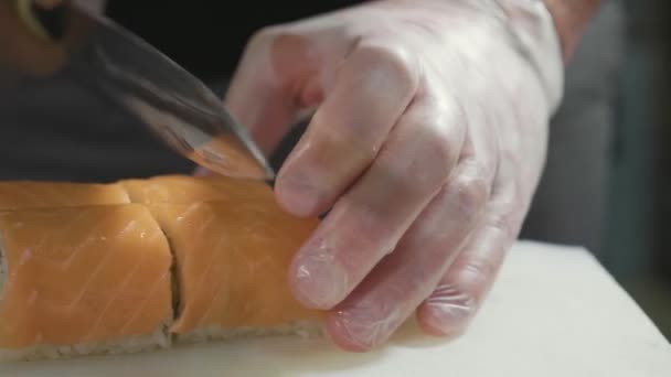 Professional sushi chef preparing roll at commercial kitchen, close-up. — Stock Video