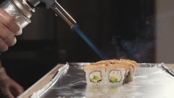 Professioneller Sushi-Koch bereitet Brötchen über Feuer in der Großküche zu, Nahaufnahme. — Stockvideo