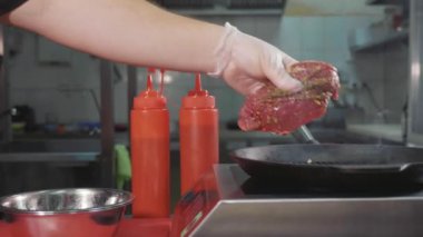 Slayt yavaş yemek biftek et bir ızgara tava koyar.