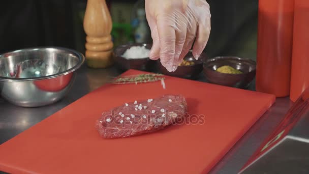 Chef-kok rauw vlees voor het voorbereiden van de steak op commerciële keuken, marineren close-up — Stockvideo