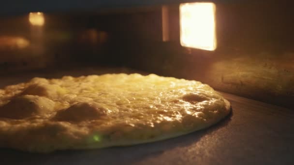 Strzał szczegół panoramowanie pizza do pieczenia w piekarniku, zwolnionym tempie — Wideo stockowe