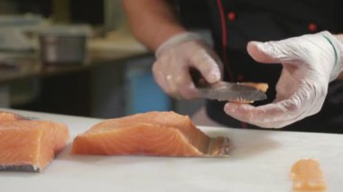 Suşi şefi eldiven Close-Up taze somon suşi barda dilimler..