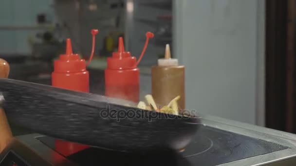 Szakács fries különböző zöldségek és a hús a egy forró serpenyőben vajjal — Stock videók