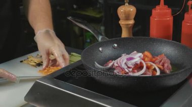 Şef çeşitli sebze ve et üzerine sıcak bir tavada tereyağı ile patates kızartması