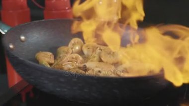 Şef karides üzerinde alkol ve yangın yakın çekim yavaş hareket ile bir tavada kızartma.