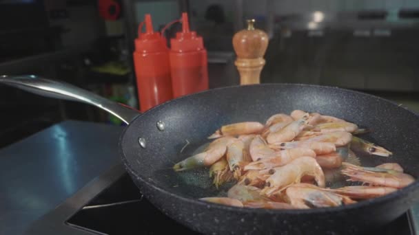 Креветки жарят на сковороде на коммерческой кухне, крупный план замедленной съемки . — стоковое видео