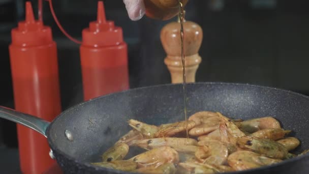 Chef pouring alcohol in pan with frying shrimps, close-up slow motion — Stock Video