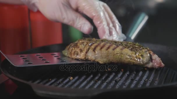 Chef-kok neemt en bereid biefstuk verwijderd grillplaat pan, close-up slow motion. — Stockvideo