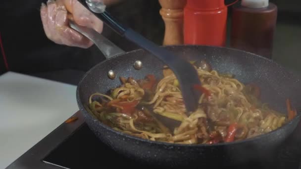 Chef frita várias verduras e carne com manteiga em uma panela de ato de fritar quente — Vídeo de Stock