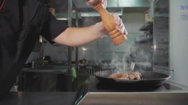 Zor durumda pan kızartma et. Şef dökme baharat biftek, yavaş pişirme