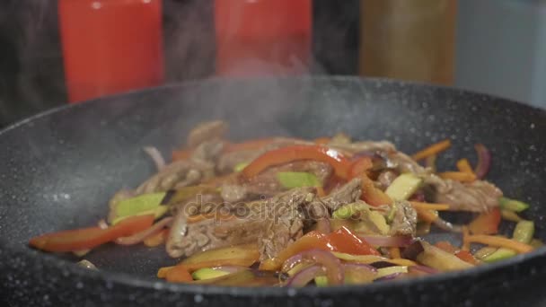요리사는 다양 한 야채와 고기는 뜨거운 프라이팬에 버터와 감자 튀김 — 비디오