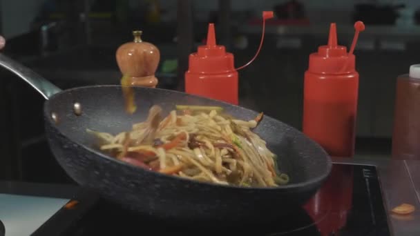 Macarrão de batatas fritas de chef com várias verduras e carne em uma panela de ato de fritar quente — Vídeo de Stock