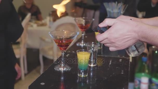 De barman bereidt een cocktail en steekt deze in brand. — Stockvideo