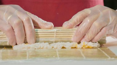 Ticari mutfak, rulo hazırlanıyor profesyonel suşi şefi yakın çekim.