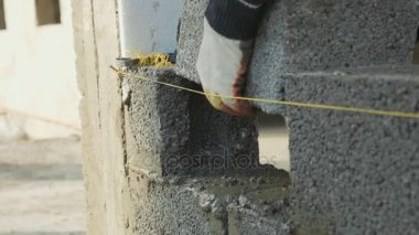 İnşaat işçisi tuğla duvar, inşaat sahasında closeup görünüm oluşturur