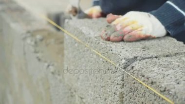 İnşaat işçisi tuğla duvar, inşaat sahasında closeup görünüm oluşturur