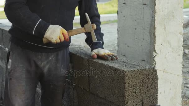 Pracownik budowlany buduje mur z cegły, widok zbliżenie na budowie — Wideo stockowe