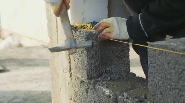 İnşaat işçisi tuğla duvar, inşaat sahasında closeup görünüm oluşturur