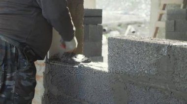 İnşaat işçisi tuğla duvar, inşaat sahasında closeup görünüm oluşturur