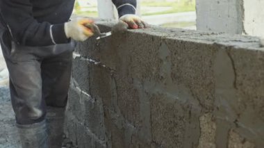 İnşaat işçisi tuğla duvar, inşaat sahasında closeup görünüm oluşturur