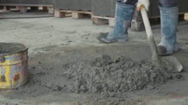 Bir beton karıştırma kürekle çalışan ve kova inşaat sahasında koyar.
