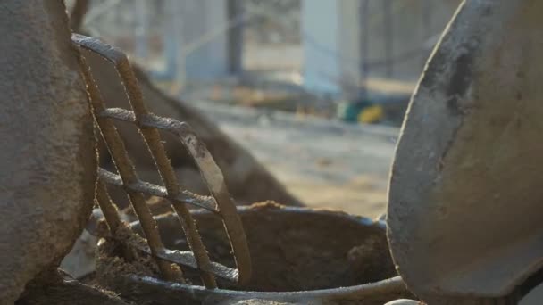 Trabalhador caucasiano derrama areia em um misturador de concreto por pá no local de construção — Vídeo de Stock