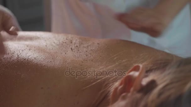 Spa therapeut scrub toe te passen op jonge vrouw terug op luxe beauty salon. — Stockvideo